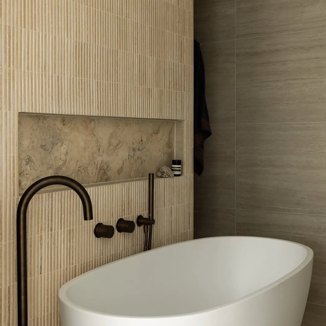 Bathroom with freestanding bath, fluted wall tiles, stone niche and matte black tapware