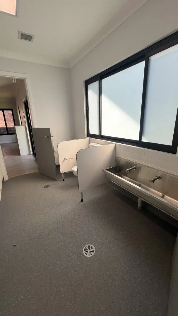 Childcare fitout bathroom with stainless steel trough basins