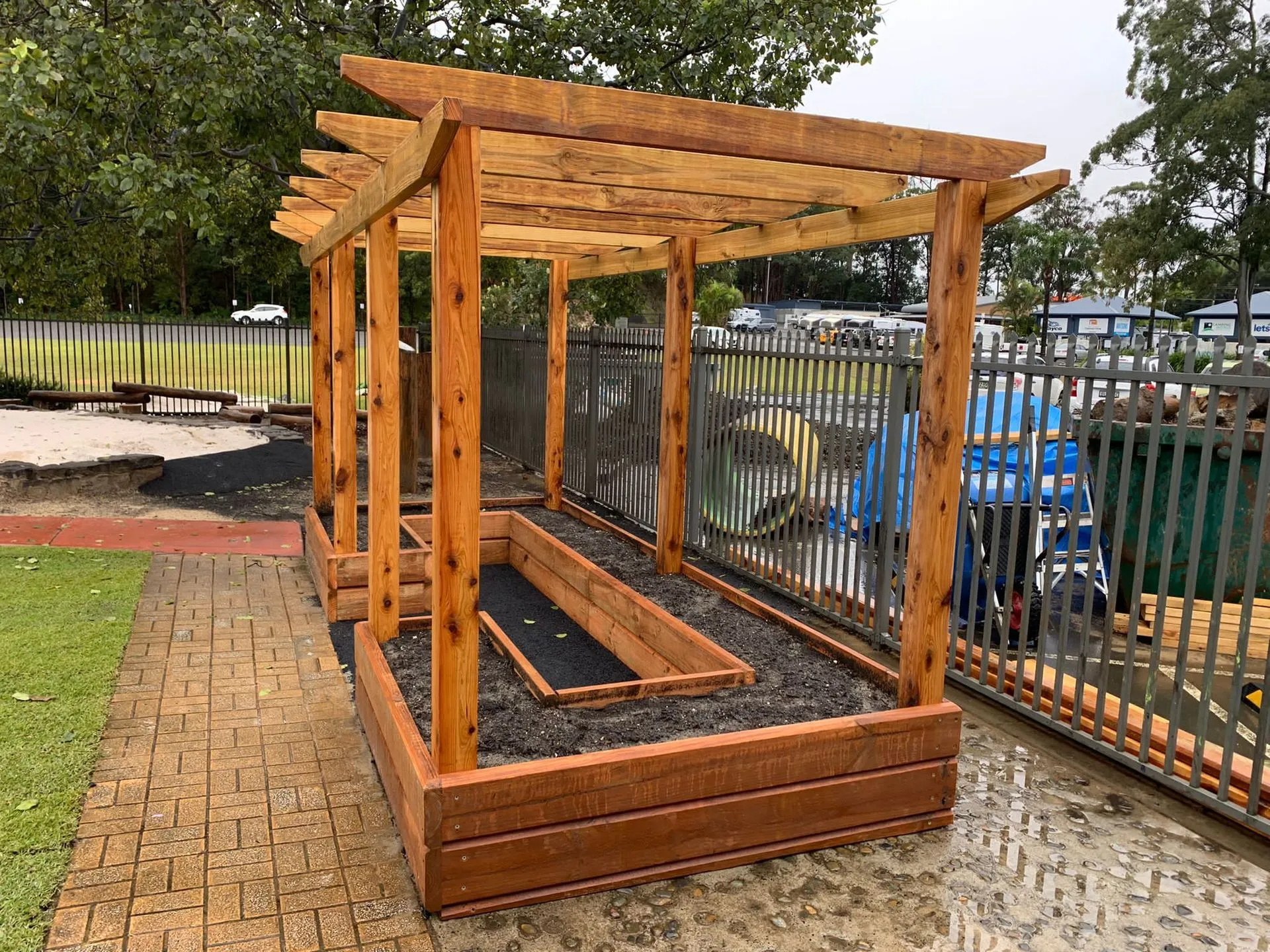 Timber pergola over raised garden beds in a childcare centre playground