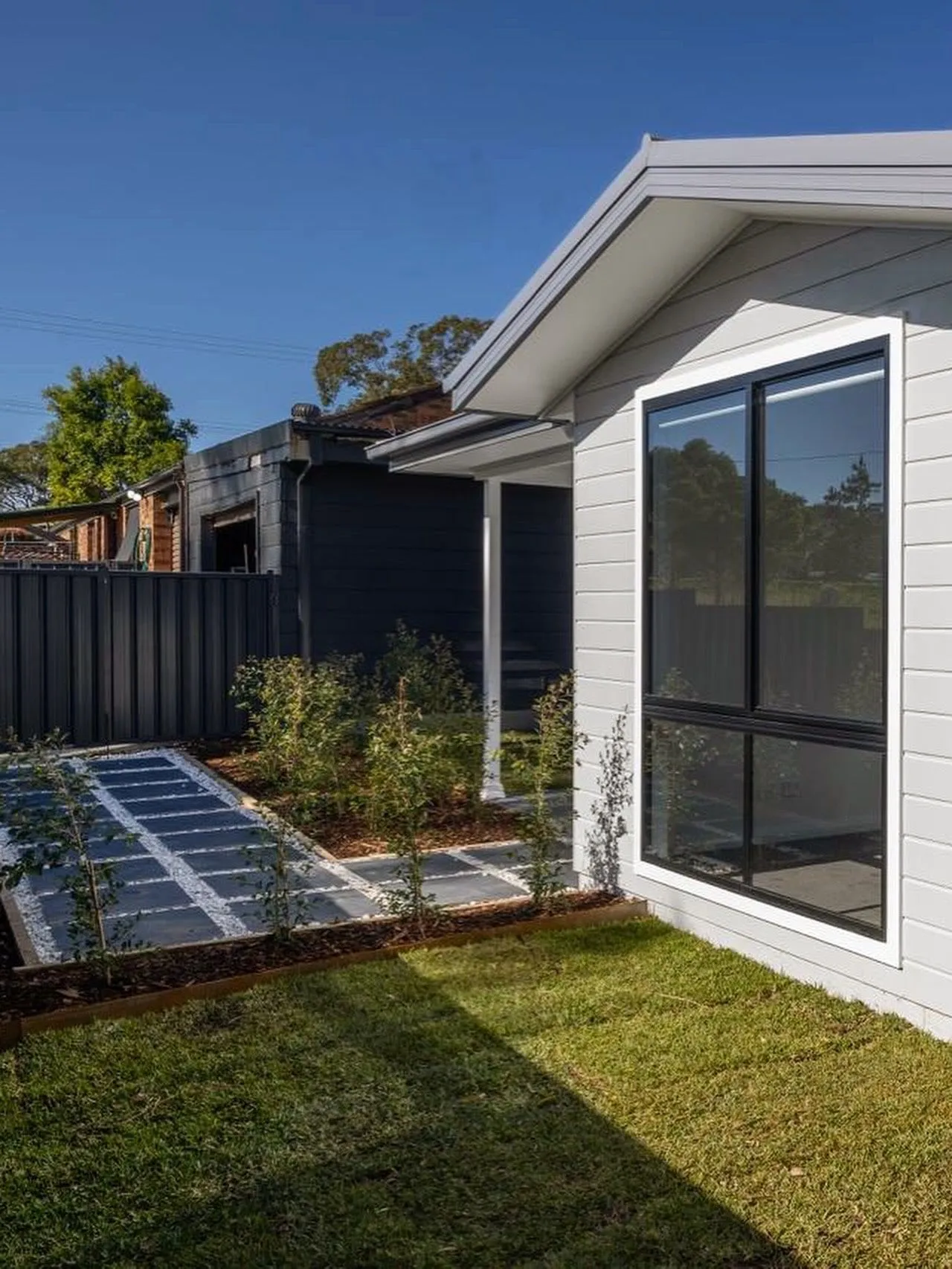 Exterior of the new weatherboard secondary dwelling at Halekulani with landscaped lawn