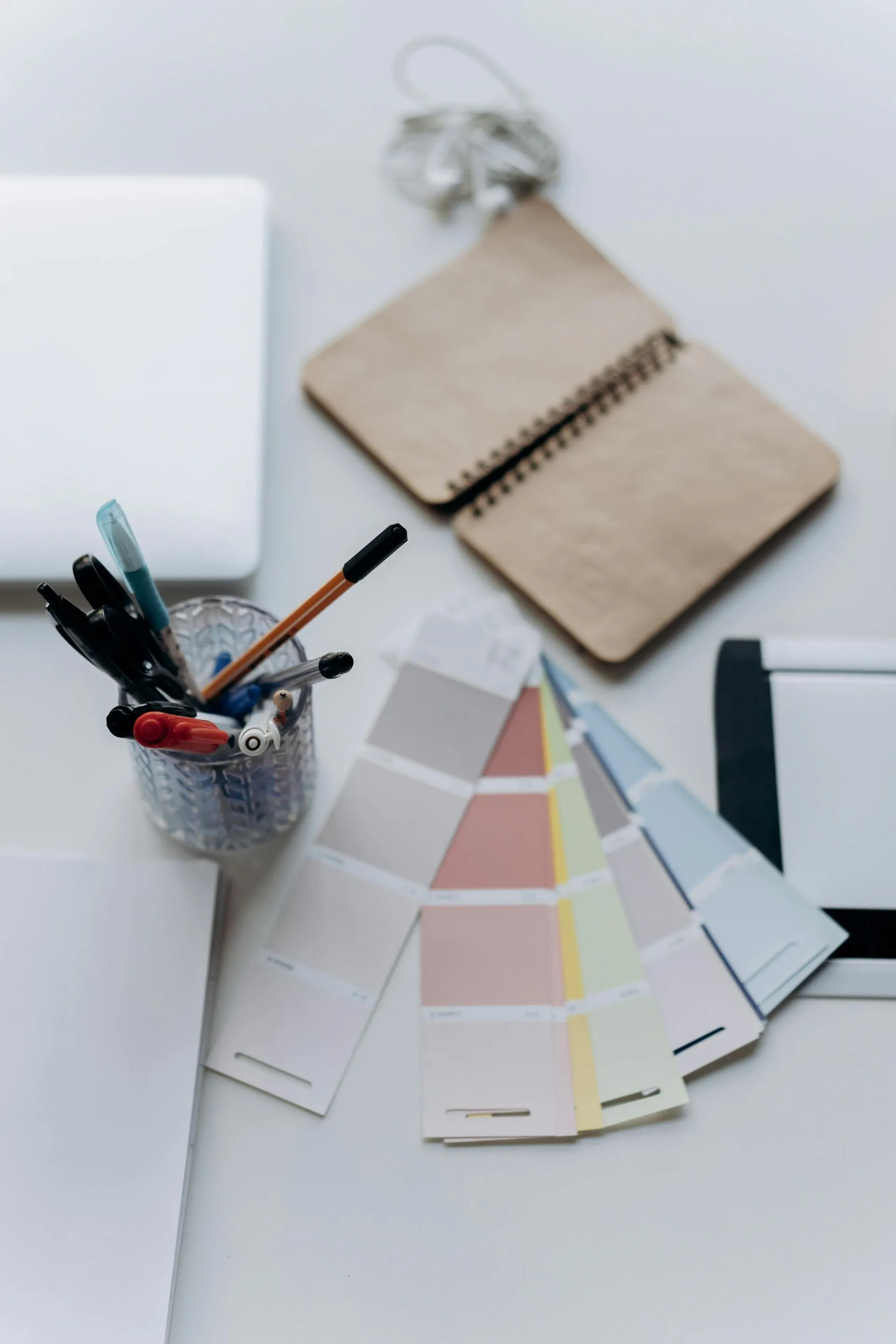 Interior design colour swatches, notebook and pens on a desk