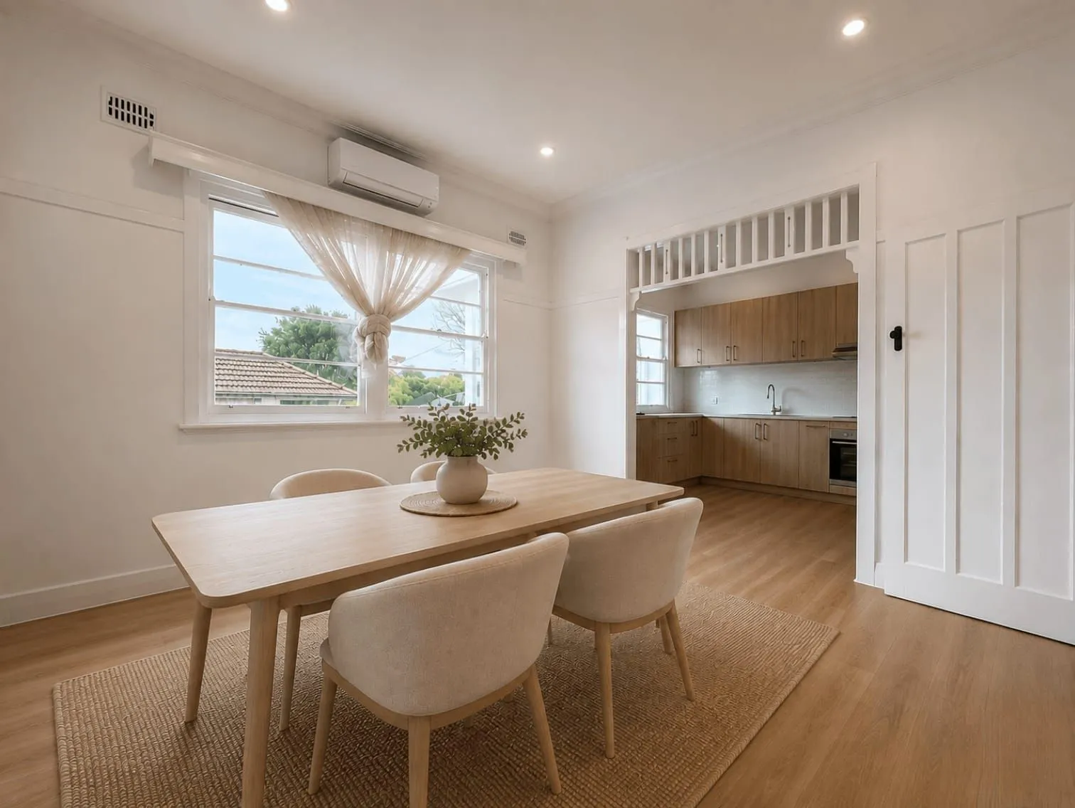 Bright dining room with timber flooring and a heritage arch through to the kitchen, Wyong whole home renovation